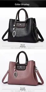 Détail de la texture croco et du pendentif perle sur un grand sac à main spacieux