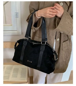 Detail of Radley London black tote bag featuring matte texture and leather handle