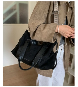Detail of black suede tote bag with leather handles and ethnic patterned shoulder strap