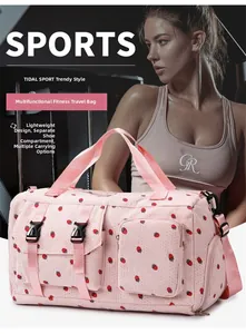Detail of pink duffel bag with cherry prints featuring separate shoe compartment and pockets