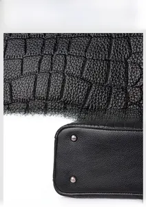 Gros plan sur la texture cuir crocodile noir et les clous de protection en métal argenté