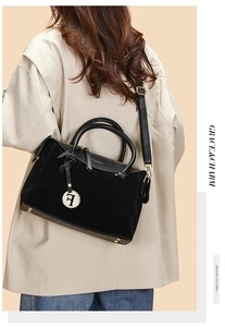 Detail of suede and leather paneling on black Boston bag with golden F charm and studs