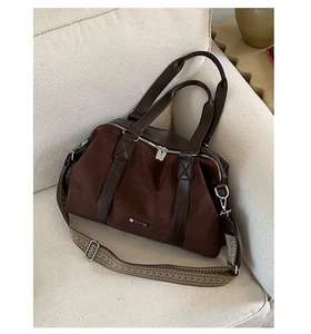 Close-up of suede tote bag showing leather straps and jacquard shoulder strap details