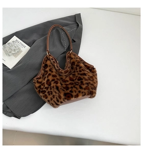 Detail of leopard print faux fur tote bag with brown leather handles and soft texture