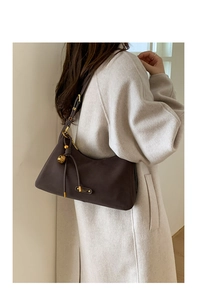 Detailed view of vintage dark brown shoulder bag featuring gold hardware and adjustable strap