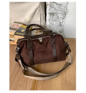 Macro detail of the brown suede Boston bag showing texture and leather strap accents