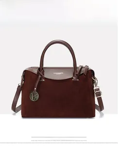 Detail of burgundy leather Boston bag showing gold F charm and suede texture contrast