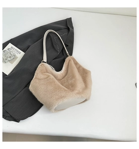 Detail of beige plush tote bag with white leather straps and metallic ring accents