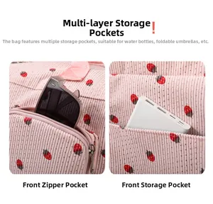Detail view of pink corduroy travel bag with strawberry print and functional front pockets
