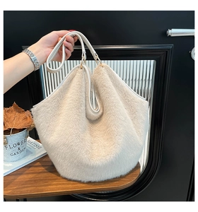 Detailed view of plush cream faux fur tote bag with leather handles and metal hardware