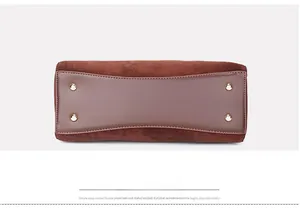 Detail of vintage brown Boston bag base with four golden protective metal studs and stitching