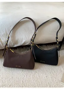 Close-up of crescent underarm bags with adjustable straps and gold metal hardware