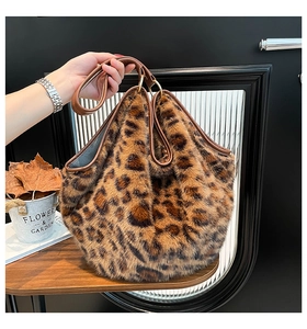 Detail of leopard print faux fur tote with brown leather handles and golden metal rings