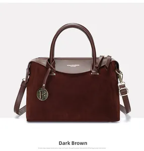Detail of light brown suede boston bag featuring gold F charm and embossed text