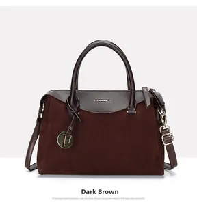Detail of dark brown Boston bag featuring matte and smooth leather textures and gold pendant