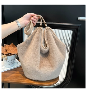 Detail of plush faux fur tote bag with leather handle and golden metal ring hardware