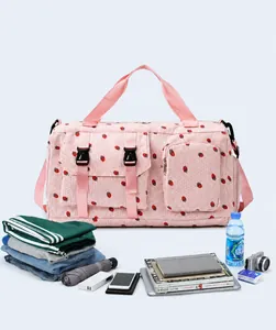 Pink strawberry print travel bag showing large capacity with various travel accessories