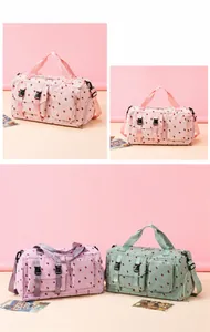 Detail of strawberry print corduroy travel bags with multiple pockets and pink straps