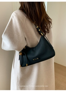 Detail of lychee leather texture and golden FANTOR LONDON logo on black hobo bag
