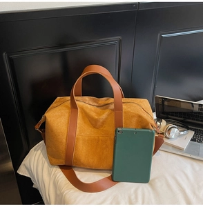 Primer plano de bolso tote de ante amarillo jengibre con detalles de correas de cuero
