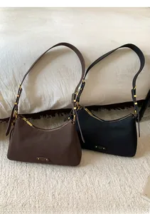 Close-up of vintage matte leather underarm bags in brown and black with gold hardware
