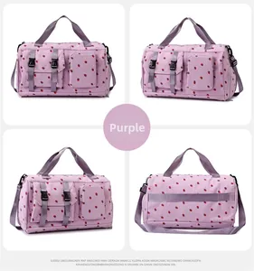 Detail view of purple travel bag with cherry print, dual handles, and side pockets