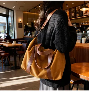 Detalle de un gran bolso tote de gamuza amarillo mostaza con asas de cuero marrón