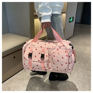 Detail of pink corduroy travel bag with cherry print and multi-pocket design