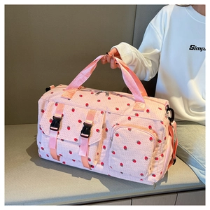 Detailed view of pink cherry print travel bag showing front pockets with black buckles