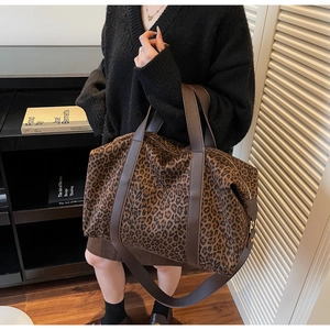 Detail of leopard print tote bag with brown leather straps and large capacity for travel