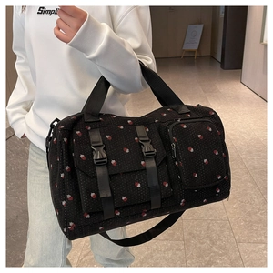 Close-up of strawberry print travel bag with functional front buckle pockets and straps