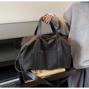 Vista detallada del bolso tote minimalista negro en estante con correa ajustable