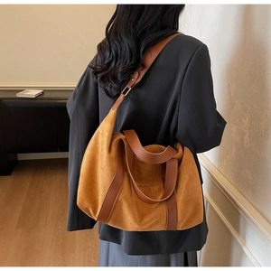 Bolso tote de ante marrón en modelo mostrando su gran capacidad para el trabajo y diario