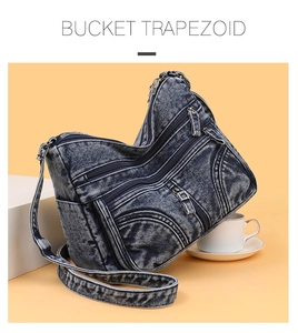 Dettaglio borsa a tracolla in denim blu con tre tasche a zip e cinturino regolabile