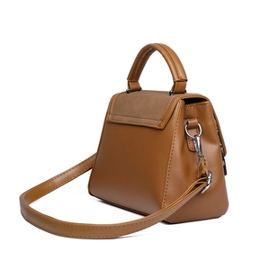 Caramel brown handbag with suede panels and silver hardware in a stylish trapezoid design