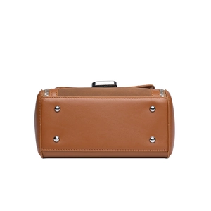 Bottom view of brown leather handbag featuring silver protective studs and fine stitching