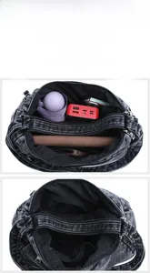 Dettaglio della borsa a tracolla in denim nero con scomparti multipli e grande capienza