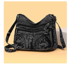 Dettaglio borsa a tracolla in denim nero lavato con tasche multiple e texture invecchiata