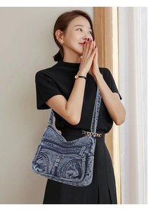 Vista dettagliata della borsa a tracolla in denim con tasche zip e cinturino su una modella