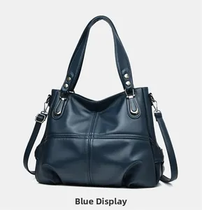 Dettaglio della borsa tote blu in pelle martellata con cuciture incrociate e fibbie argentate