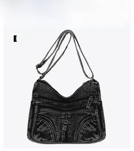 Vista frontale della borsa a tracolla in denim grigio scuro vintage con tasche a zip