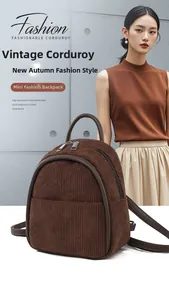 Detail view of mini corduroy backpack in brown featuring front zipper pocket