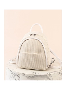 Detail of beige corduroy mini backpack with white leather handles on a display stand