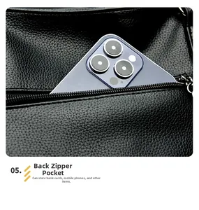 Dettaglio borsa tote in pelle nera con tasca posteriore e smartphone di grandi dimensioni