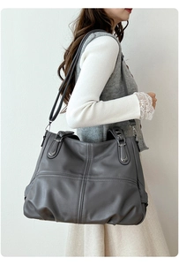 Dettaglio della borsa tote grigio scuro minimalista con cuciture a croce in pelle PU