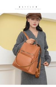 Close-up of brown PU leather backpack with contrasting woven strap and multi-pocket design