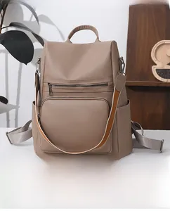 Detail of khaki PU leather backpack with side pockets and stylish striped shoulder strap