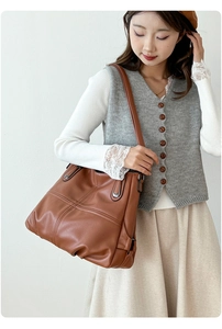 Borsa tote in pelle marrone con cuciture a contrasto indossata da una modella