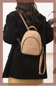 Detail of corduroy texture and leather strap on a small khaki backpack for women