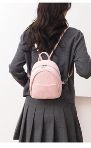Pink corduroy mini backpack for women worn by model showing casual style and compact size